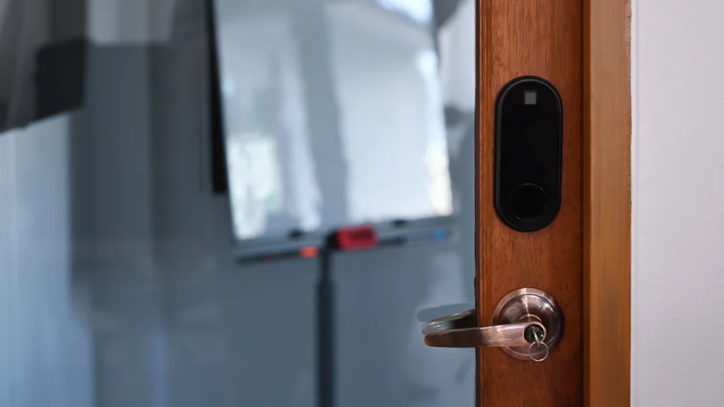 A close-up shot highlights a modern door lock with a wooden frame and black digital interface